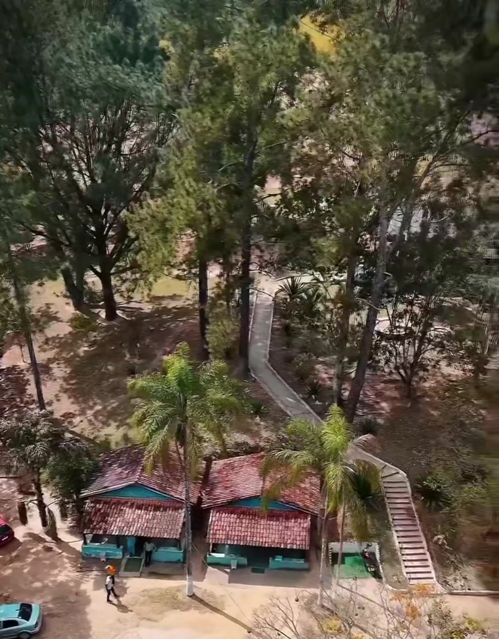 Vista aérea dos pavilhões e caminhos da Comunidade Há Uma Esperança Jesus, entre árvores, em Caçapava/SP